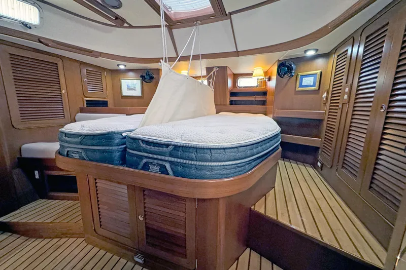 Slide: The Image of Luxurious 2012 Hylas 49CC yacht interior with wooden finishes and cozy bedding. - 132