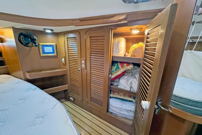Slide: The Image of Cozy cabin interior of 2012 Hylas 49CC yacht with wooden storage and bedding. - 134
