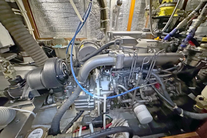 Slide: The Image of Engine room of a 2012 Hylas 49CC yacht, showcasing complex machinery and wiring. - 144