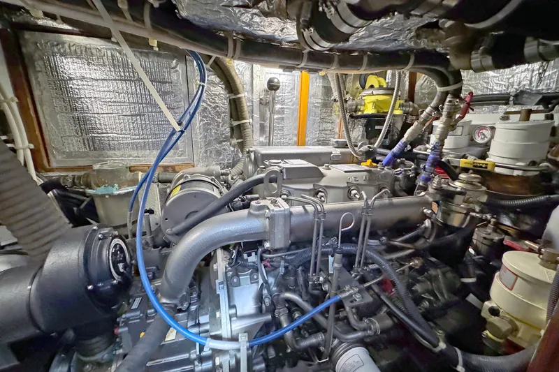 Slide: The Image of Engine room of a 2012 Hylas 49CC yacht, showcasing complex machinery and piping. - 145