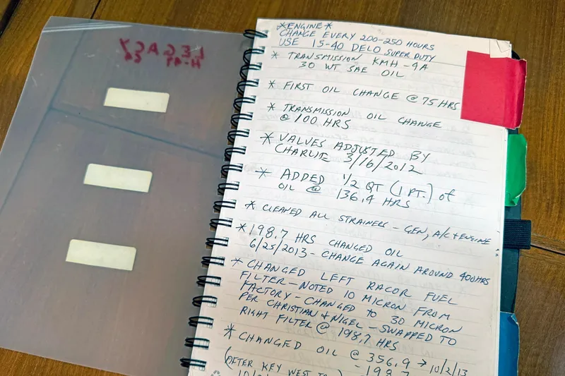 Slide: The Image of Notebook with handwritten maintenance notes for a 2012 Hylas 49CC engine. - 156