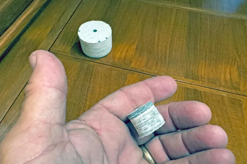 Slide: The Image of Hand holding a small cylindrical object on a wooden surface, Hylas 49CC 2012 model. - 159