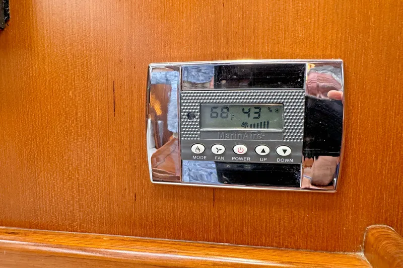 Slide: The Image of Thermostat on Hylas 49CC yacht, displaying 68°F and 43% humidity, mounted on wooden panel. - 172