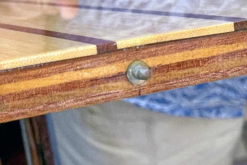 Slide: The Image of Close-up of a Hylas 49CC 2012 wooden table edge with visible screw detail. - 179