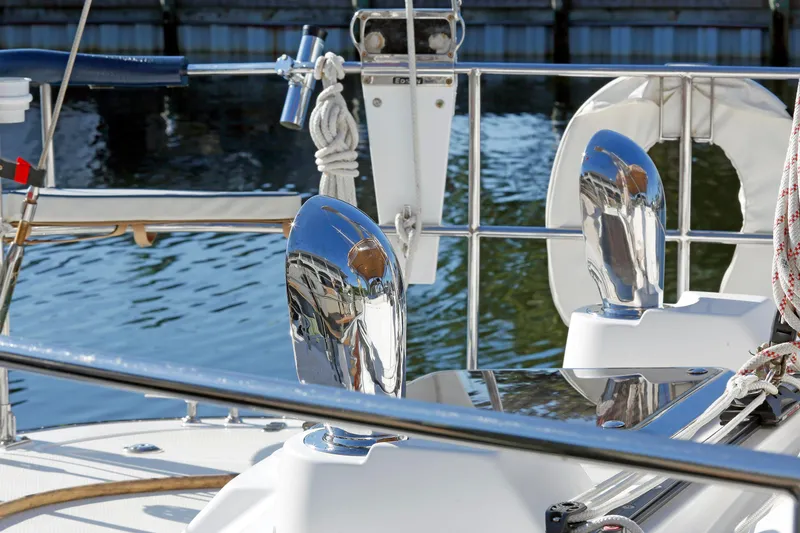Slide: The Image of Polished chrome details on a 2012 Hylas 49CC yacht deck by the water. - 30