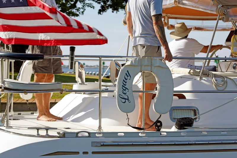 Slide: The Image of People on a 2012 Hylas 49CC sailboat named "Legacy" with an American flag. - 39