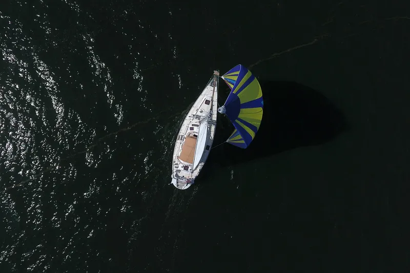 Slide: The Image of Aerial view of 2012 Hylas 49CC sailboat with colorful spinnaker on dark water. - 5