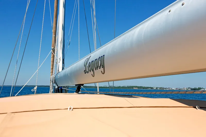 Slide: The Image of Sailboat Hylas 49CC 2012 with "Legacy" on boom, sailing on clear blue water. - 56
