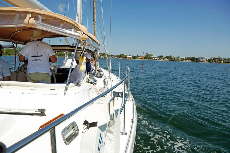 Slide: The Image of Sailing on a 2012 Hylas 49CC yacht near a coastal shoreline under clear blue skies. - 87