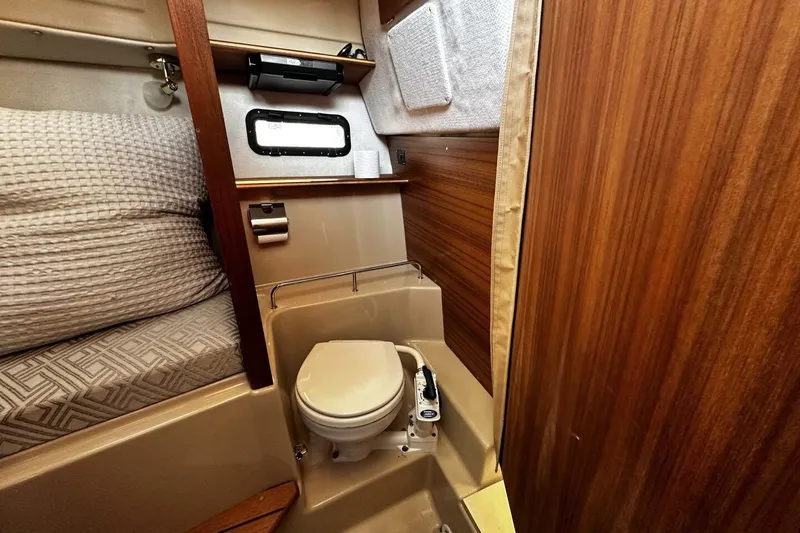 Slide: The Image of 2019 Ranger Tugs R-23 boat interior with compact bathroom and wooden accents. - 11