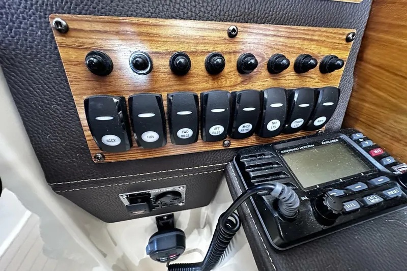Slide: The Image of Control panel of a 2019 Ranger Tugs R-23 boat with switches and radio. - 16