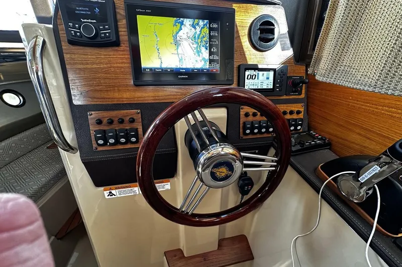 Slide: The Image of 2019 Ranger Tugs R-23 helm with Garmin navigation, wood accents, and modern controls. - 20