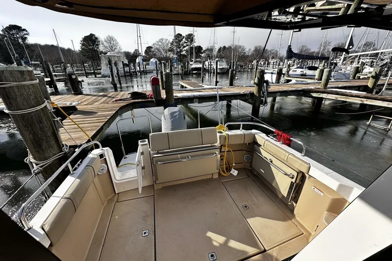 Slide: The Image of 2019 Ranger Tugs R-23 boat docked at marina, featuring spacious deck and seating area. - 21