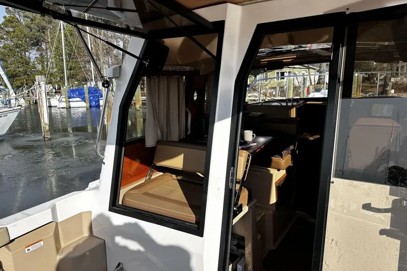 Slide: The Image of 2019 Ranger Tugs R-23 boat interior with seating and table, docked at marina. - 24