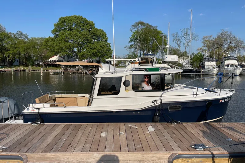 Slide: The Image of 2019 Ranger Tugs R-23 boat docked at marina, sunny day, trees in background. - 30