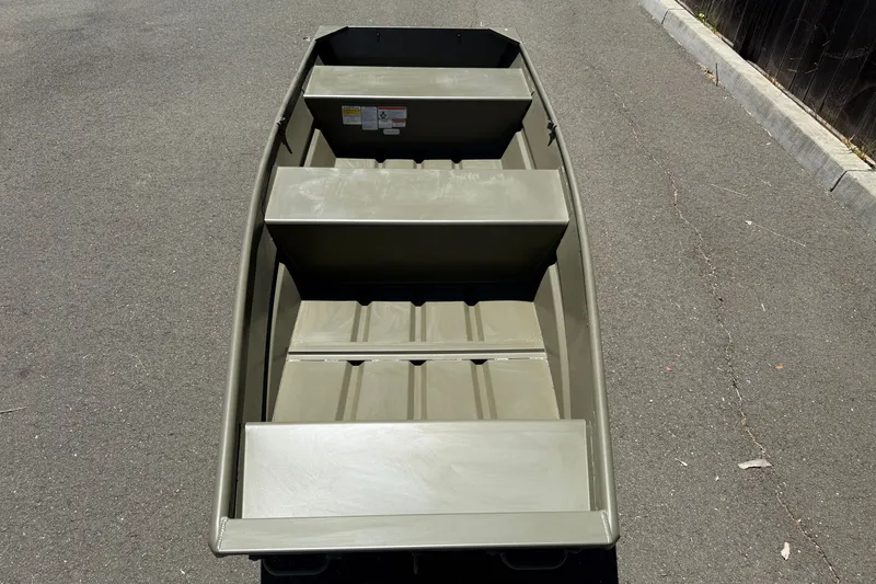 Slide: The Image of 2026 Tracker Grizzly 12 Jon boat on pavement, showcasing interior seating and design. - 7