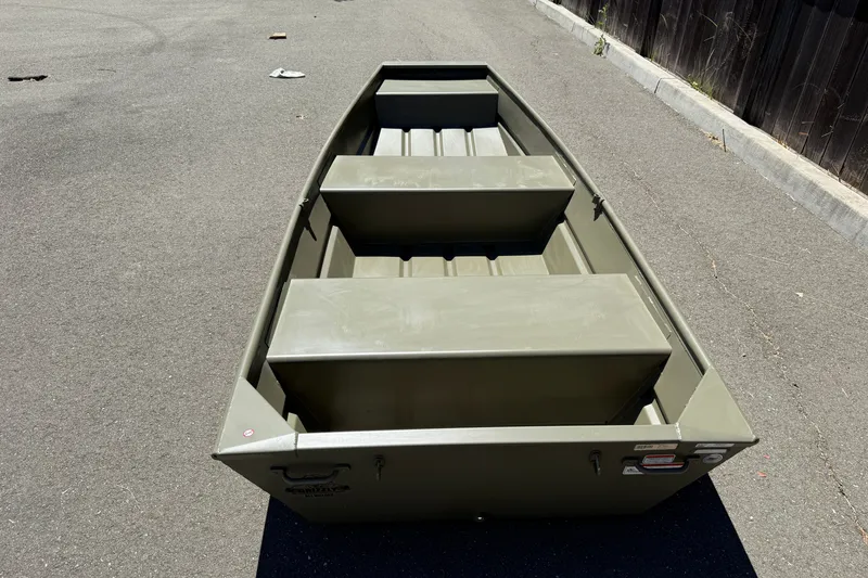 Slide: The Image of 2026 Tracker Grizzly 12 Jon boat on pavement, showcasing its sturdy design and seating arrangement. - 5