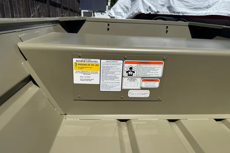 Slide: The Image of 2026 Tracker Grizzly 12 Jon boat capacity and safety warning labels. - 11