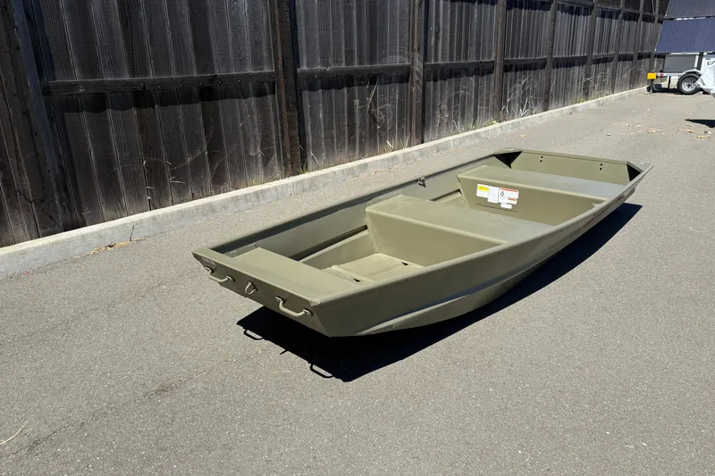 Slide: The Image of 2026 Tracker Grizzly 12 Jon boat on pavement, near wooden fence. - 8