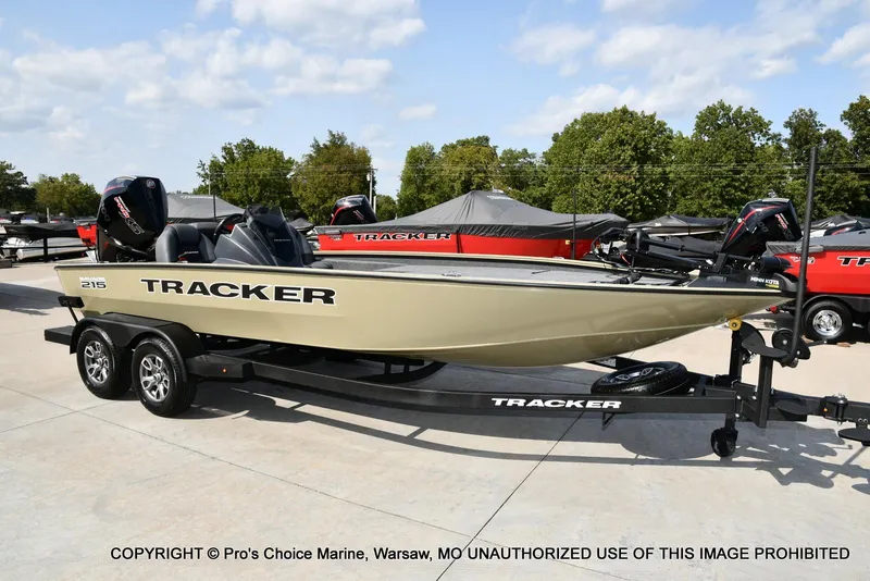 The Image of 2026 Tracker Savage 215 boat on trailer, displayed outdoors with trees in background. - 0