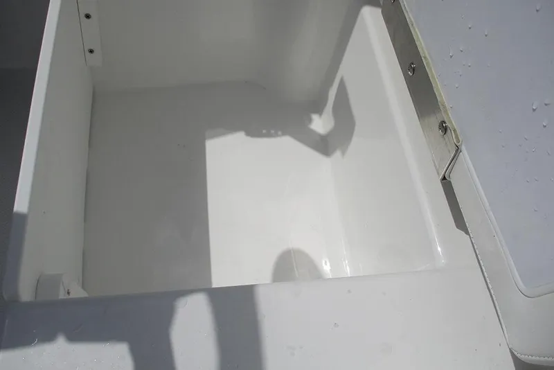 Slide: The Image of 2026 Tahoe T18 boat storage compartment, white interior, open lid, metal hinge detail. - 21