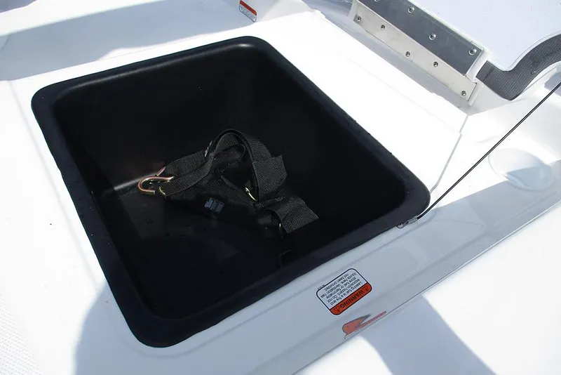 Slide: The Image of Open storage compartment on 2026 Tahoe T18 boat with black strap inside. - 24