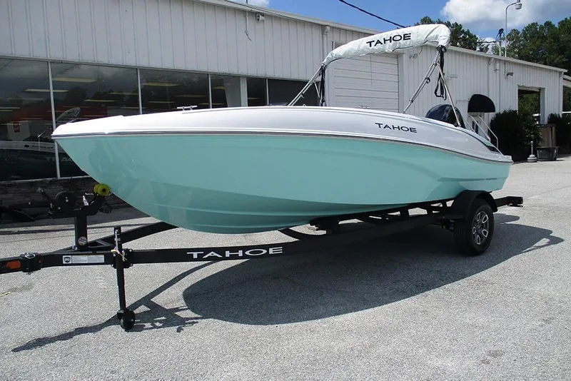 Slide: The Image of 2026 Tahoe T18 boat on trailer, light blue hull, parked outside dealership. - 5