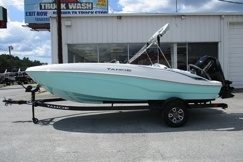 Slide: The Image of 2026 Tahoe T18 boat on trailer, parked outside a building under a clear sky. - 6