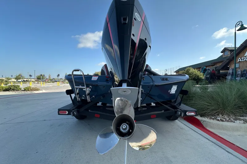 Slide: The Image of 2025 Ranger ALPHA 208 boat on trailer, rear view with propeller, outdoor setting. - 12