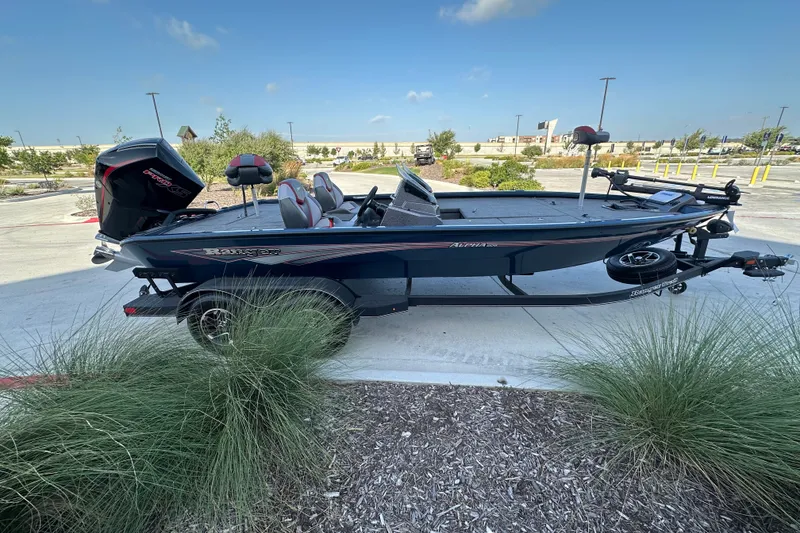 Slide: The Image of 2025 Ranger ALPHA 208 boat on trailer, parked outdoors under clear blue sky. - 5