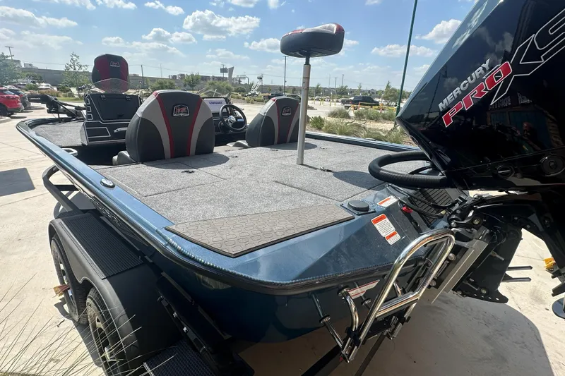 Slide: The Image of 2025 Ranger ALPHA 208 boat with Mercury Pro XS engine, parked outdoors under a sunny sky. - 2