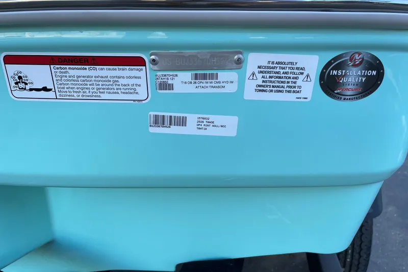 Slide: The Image of 2026 Tahoe T18 boat warning labels and installation quality certification on light blue hull. - 70