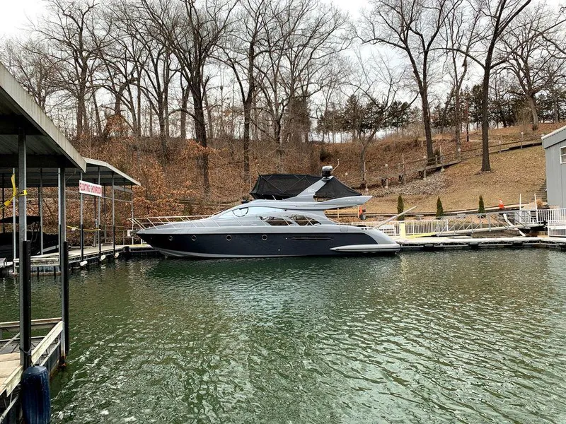 Slide: The Image of 2006 Azimut 50 yacht docked on a serene lake with bare trees in the background. - 4