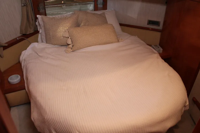 Slide: The Image of Cozy bedroom interior of 2006 Azimut 50 yacht with beige bedding and pillows. - 43