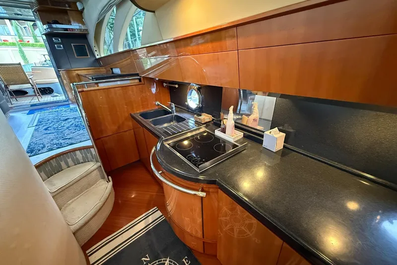 Slide: The Image of Luxurious kitchen interior of a 2006 Azimut 50 yacht with sleek wooden cabinetry. - 57