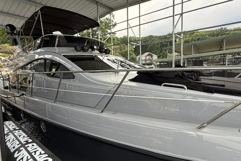 Slide: The Image of 2006 Azimut 50 yacht docked under a covered marina, showcasing sleek design and luxury features. - 8