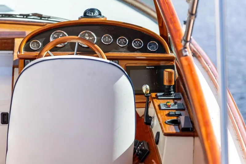 Slide: The Image of 2003 Hinckley T29R boat cockpit with wooden steering wheel and control panel. - 10