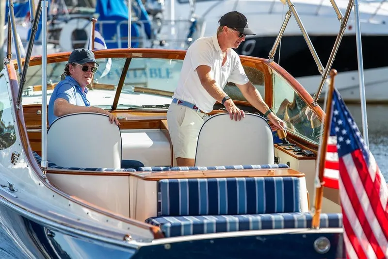 Slide: The Image of Two people on a 2003 Hinckley T29R boat with American flag, docked at marina. - 11