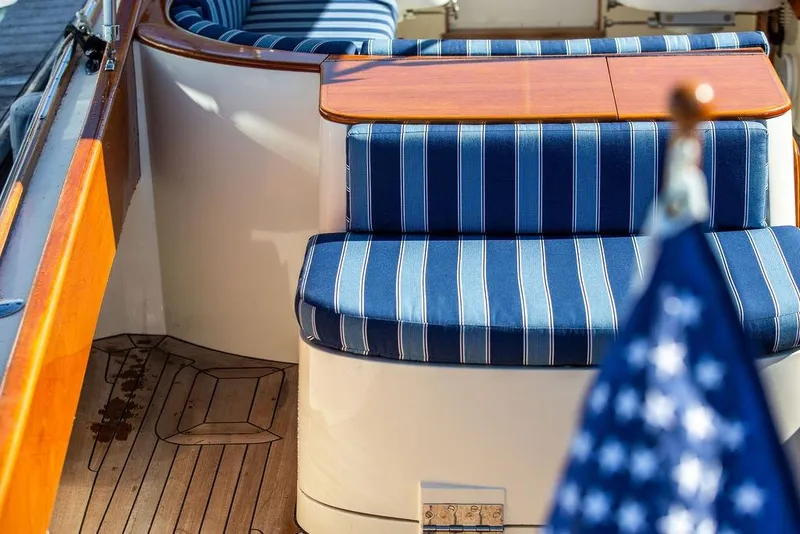 Slide: The Image of Hinckley T29R 2003 boat interior with striped blue seating and wooden accents. - 14