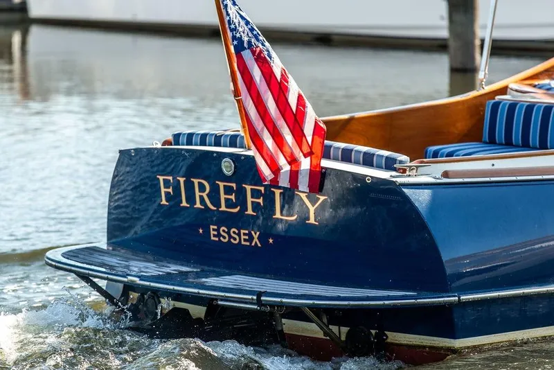 Slide: The Image of Hinckley T29R 2003 boat "Firefly" with American flag, Essex location, on water. - 15