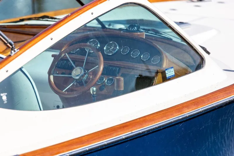 Slide: The Image of Interior view of 2003 Hinckley T29R boat, showcasing wooden steering wheel and dashboard. - 4