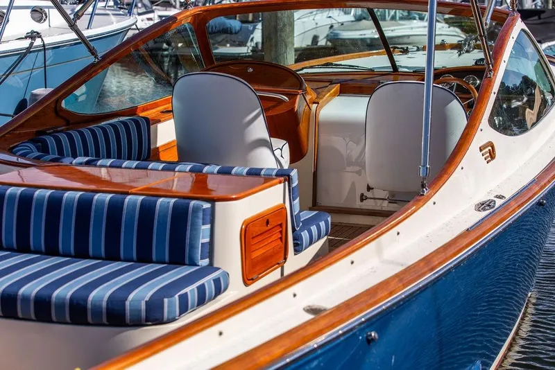 Slide: The Image of 2003 Hinckley T29R boat interior with striped seating and wooden accents. - 6