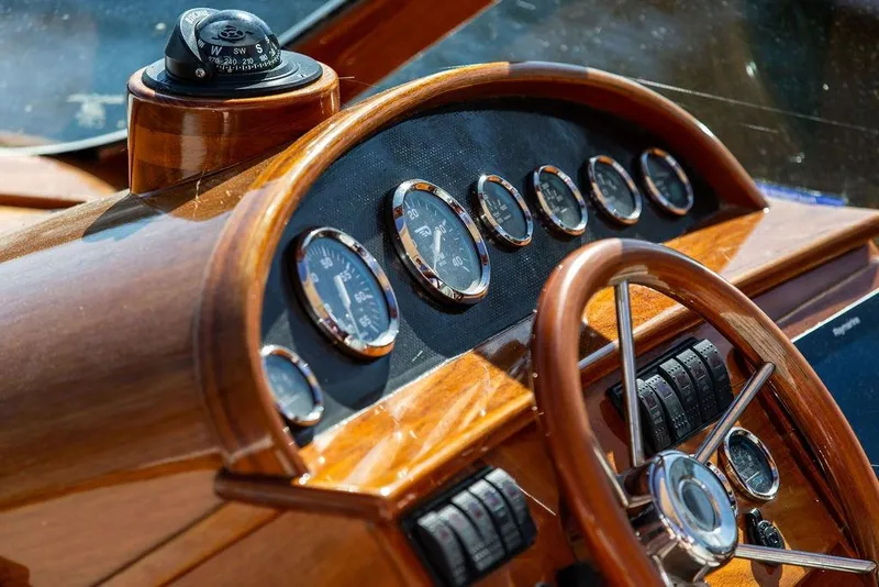 Slide: The Image of Hinckley T29R 2003 boat dashboard with wooden steering wheel and gauges. - 9
