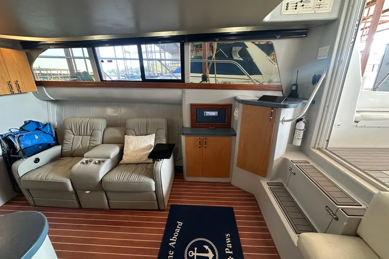 Slide: The Image of Interior of 1996 Mainship 40 Sedan Bridge with leather seating and wooden cabinets. - 16