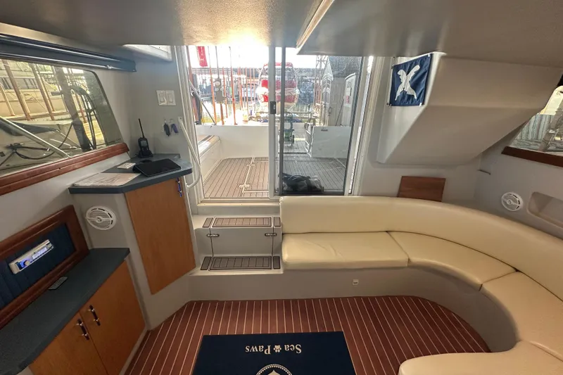 Slide: The Image of Interior of 1996 Mainship 40 Sedan Bridge with curved seating and wooden flooring. - 18