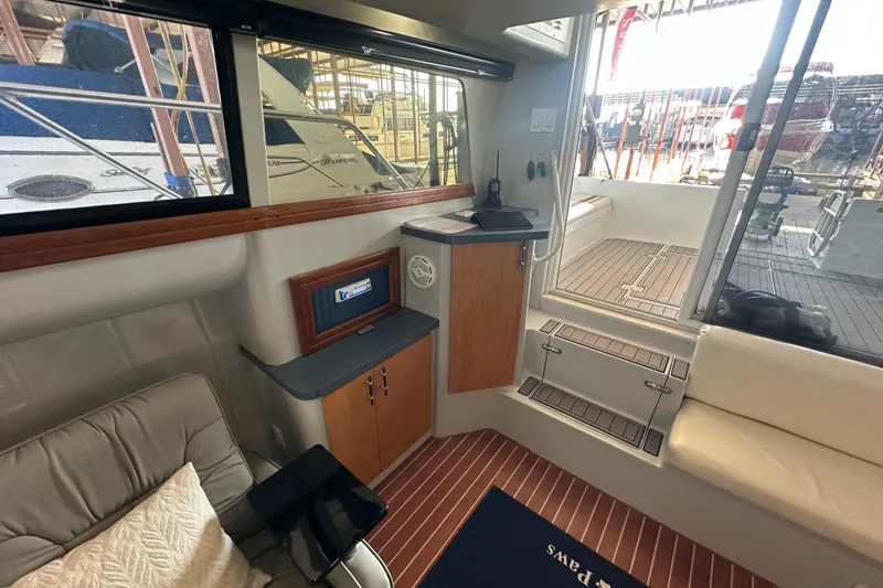 Slide: The Image of Interior of 1996 Mainship 40 Sedan Bridge with curved seating and wooden accents. - 19