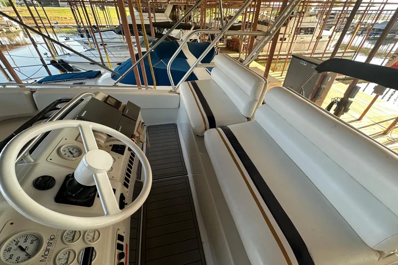 Slide: The Image of 1996 Mainship 40 Sedan Bridge helm with white seating and control panel. - 2
