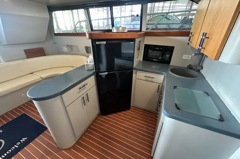 Slide: The Image of Interior of 1996 Mainship 40 Sedan Bridge with leather seating and wooden cabinetry. - 21