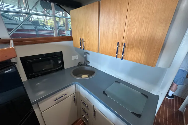 Slide: The Image of 1996 Mainship 40 Sedan Bridge kitchen with modern appliances and wood flooring. - 24