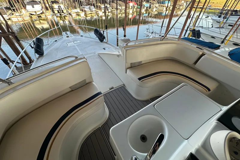 Slide: The Image of 1996 Mainship 40 Sedan Bridge helm with white steering wheel and cushioned seating. - 3